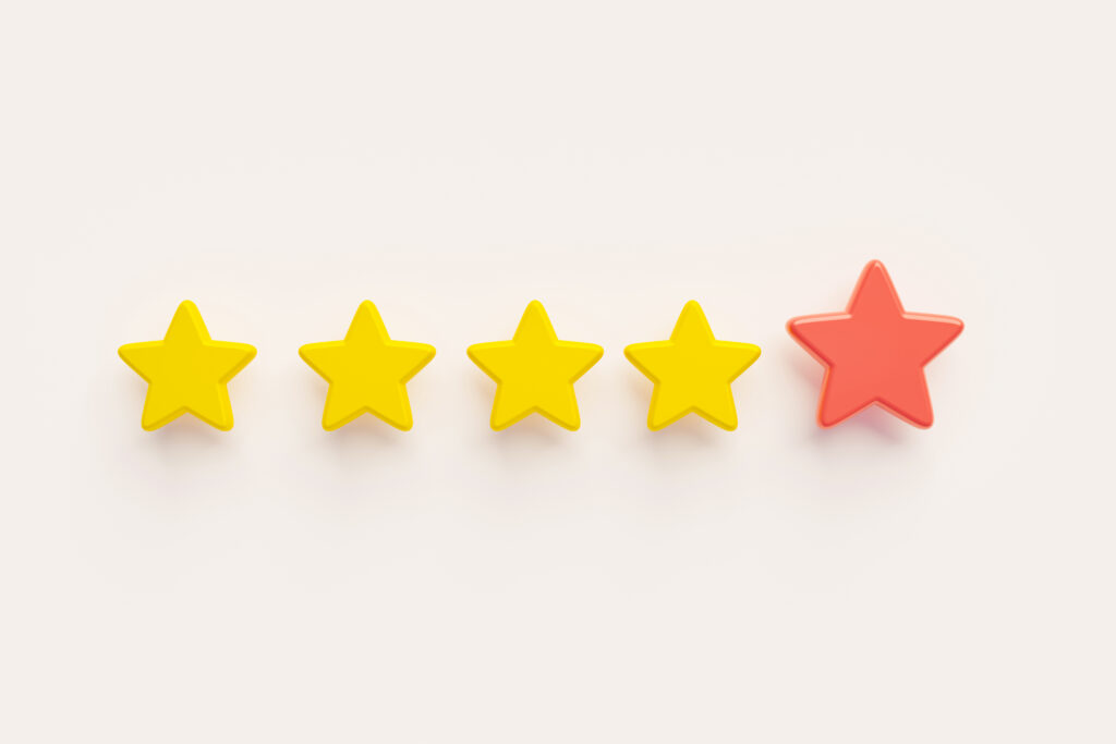 Four yellow stars and one red star on a white surface, representing declining satisfaction scores and the urgent need to improve the healthcare experience.