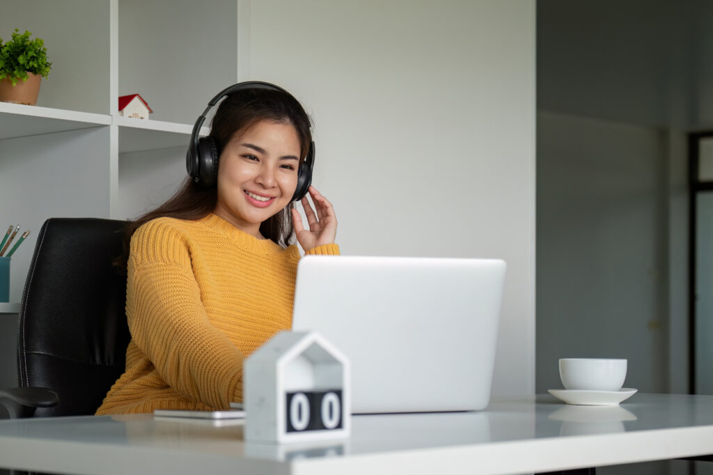 Dedicated remote healthcare specialist with headphones working on a laptop inside a practice management system