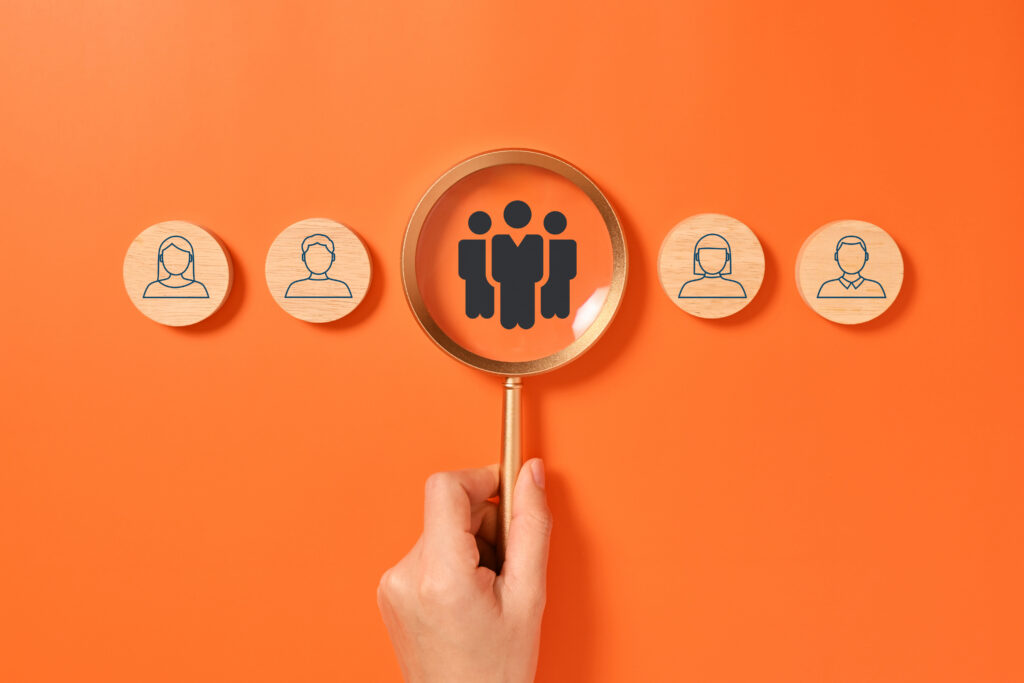 Magnifying glass evaluating remote staff icons for HIPAA compliance and credential auditing