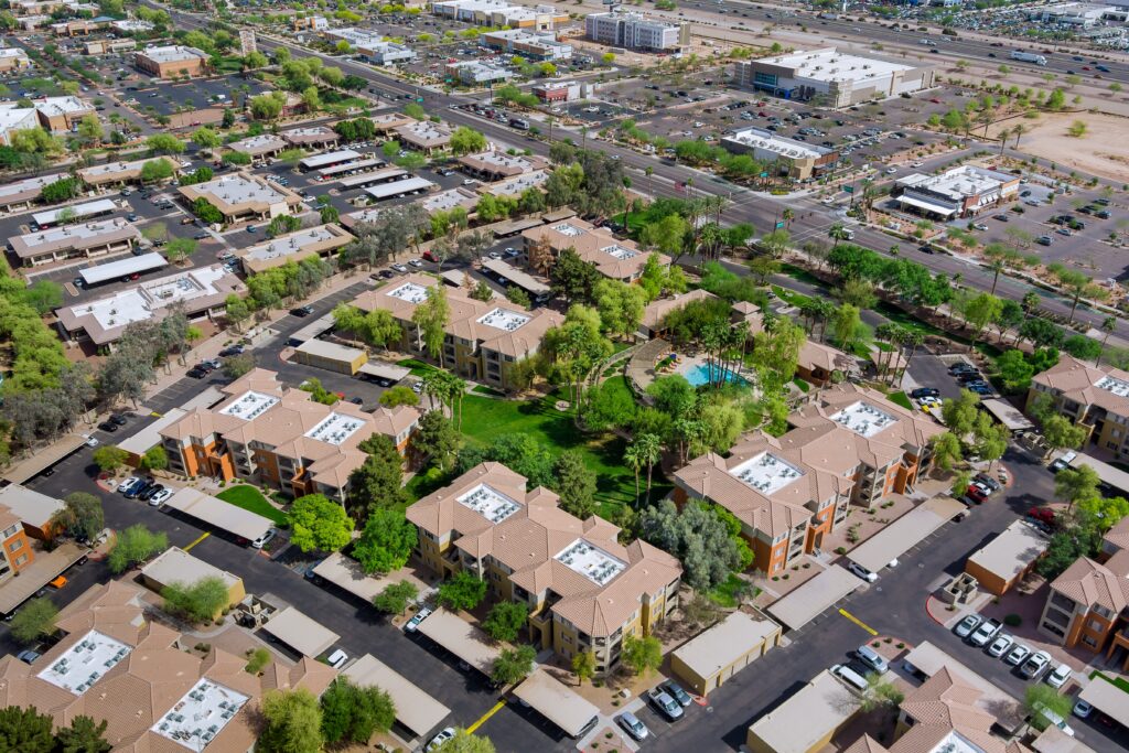 Aerial view of a suburban neighborhood and commercial developments set against the Arizona desert landscape.