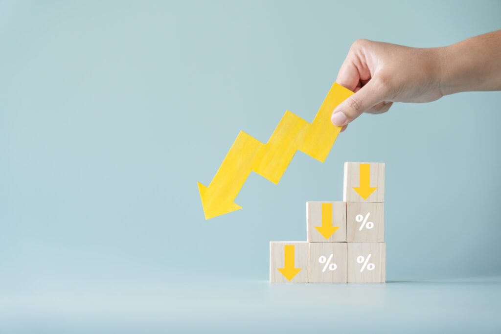 Yellow downward arrow on wooden percentage blocks representing revenue cycle labor cost reduction for healthcare organizations.