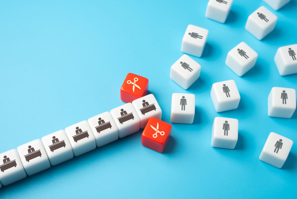 Conceptual illustration of architecture firm turnover and employee attrition represented by white blocks separated by red scissor blocks on a blue surface.