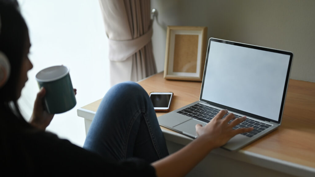 Dedicated remote revenue cycle specialist working on a laptop with daily access to electronic health record software.