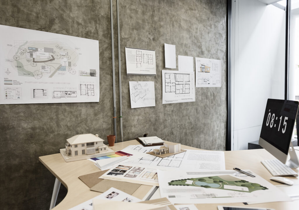 Architectural office workstation with technical models and design drawings driving AEC firm growth