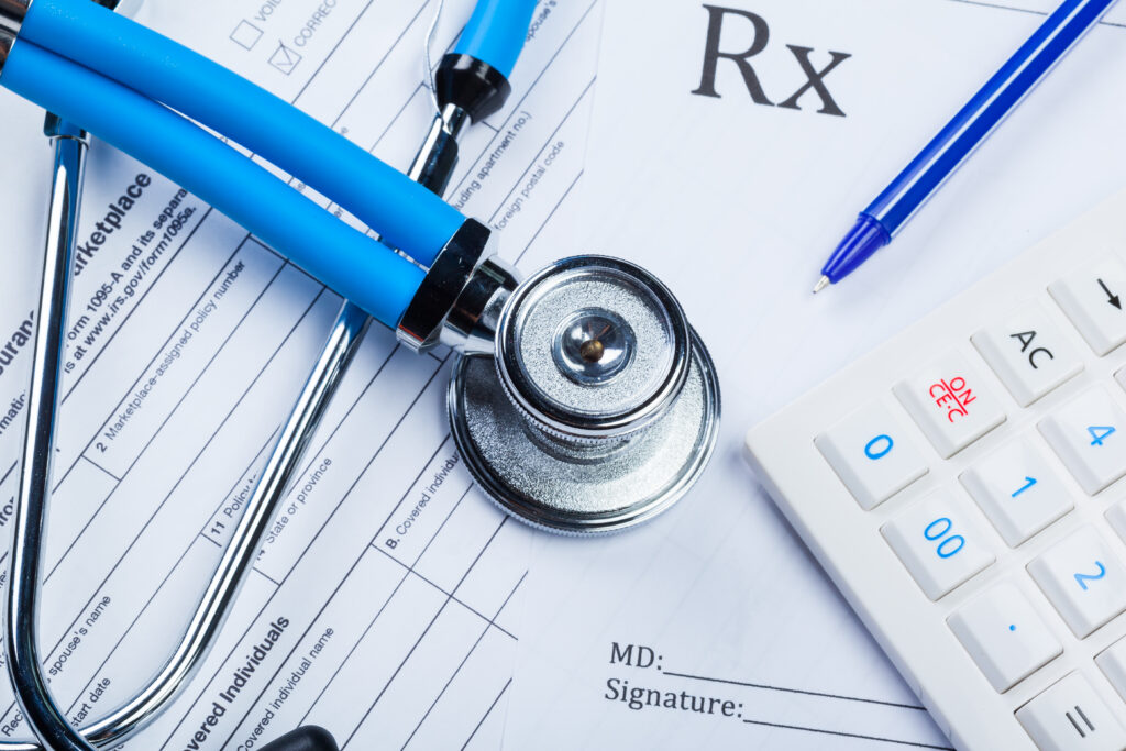 Insurance claim form with stethoscope and calculator representing medical billing costs