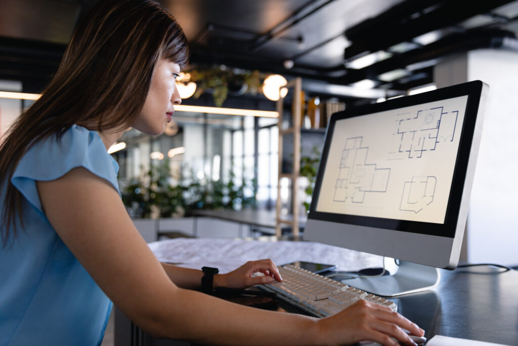 Production staff member drafting floor plans on a computer, adding production capacity at an architecture firm